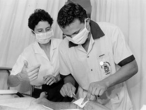 A nursing student being supervised by a clinical educator as he proceeds with a wound dressing